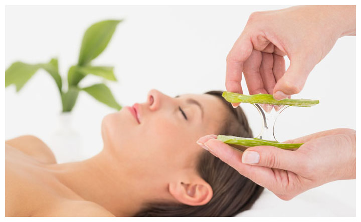 Attractive young woman receiving aloe vera massage at spa center